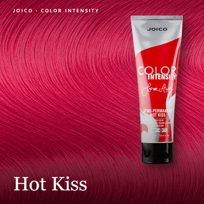 A squeeze tube of Joico Color Intensity Semi-Permanent Hair Color in the shade 'Hot Kiss' is displayed against a vibrant, saturated magenta-pink hair texture background. The tube itself is white with a bold red graphic and black text.
